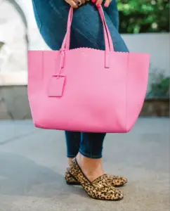 legs wearing jeans with a pink bag